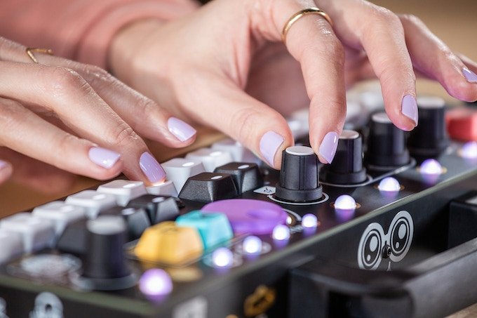 Closeup of Chelsea playing CHOMPI: pressing buttons and turning and FX knob